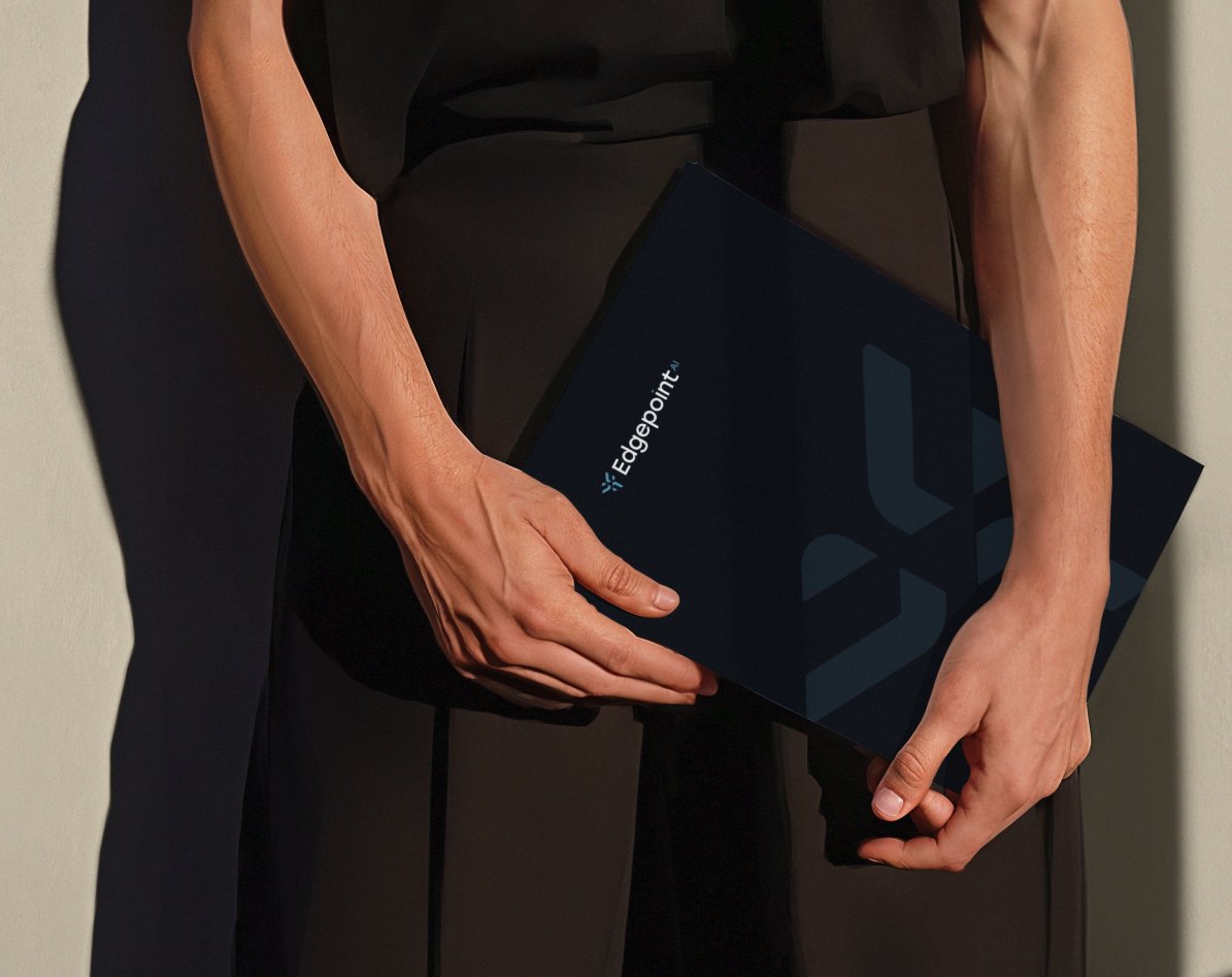 Person holding a navy Edgepoint AI brochure with the brand emblem